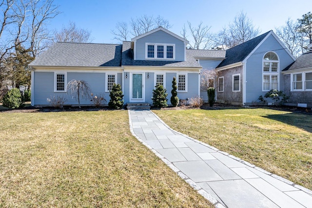 traditional-style house with a shingled roof and a front yard