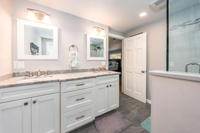 ensuite bathroom with a shower with door, a sink, ensuite bathroom, and double vanity