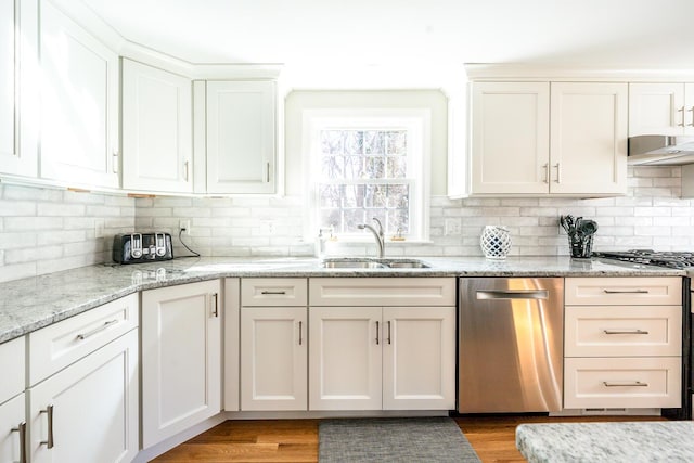 kitchen with stainless steel dishwasher, light wood-style flooring, a sink, and white cabinetry