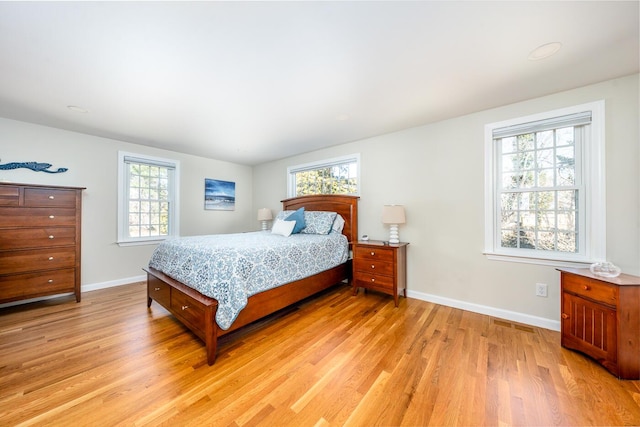 bedroom with light wood-type flooring and baseboards