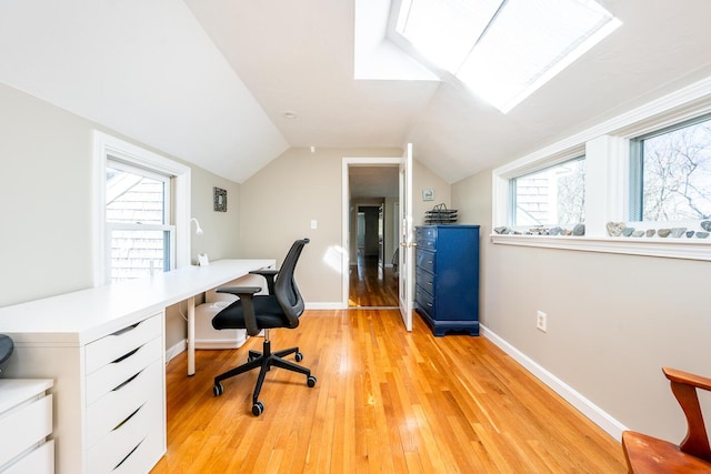 office with light wood-type flooring, baseboards, and vaulted ceiling