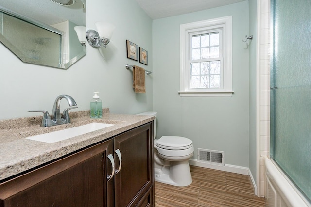 bathroom featuring visible vents, toilet, vanity, wood finished floors, and baseboards