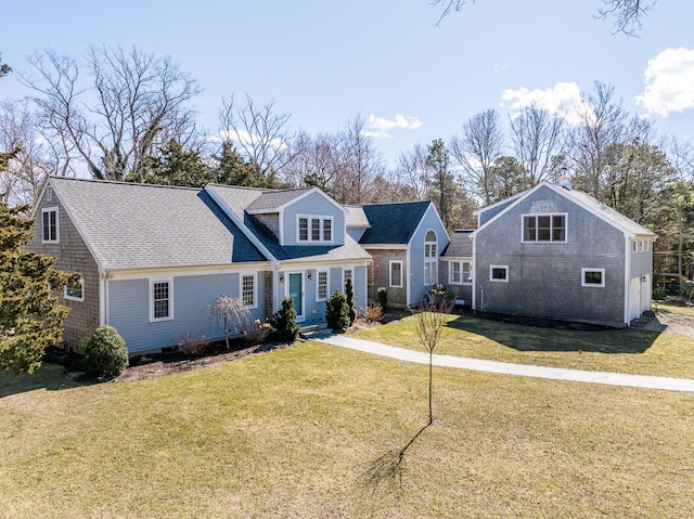 view of front of home featuring a front lawn and a shingled roof