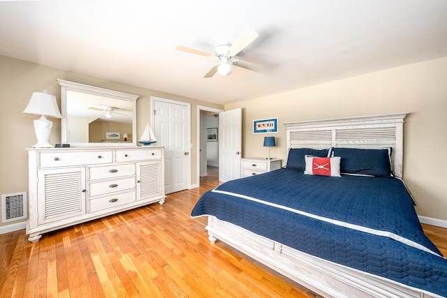 bedroom featuring light wood finished floors, baseboards, visible vents, and a ceiling fan