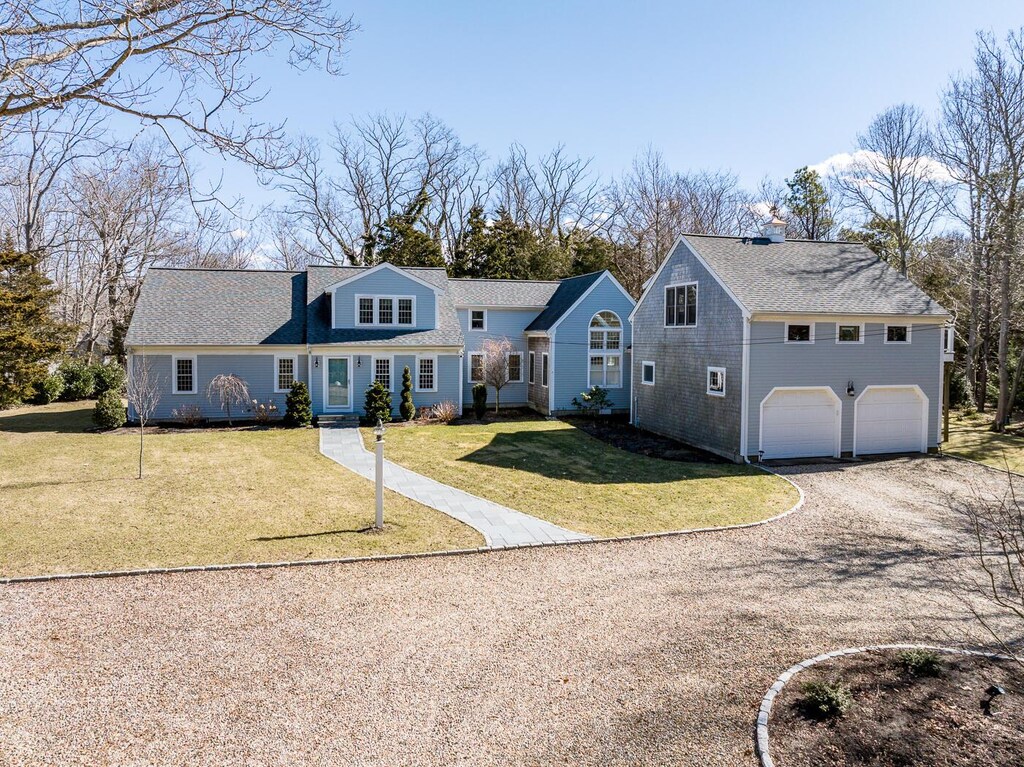 view of front of home featuring driveway, a front lawn, and an attached garage