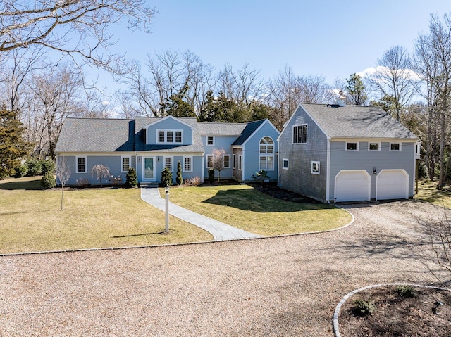 view of front of home featuring driveway, a front lawn, and an attached garage