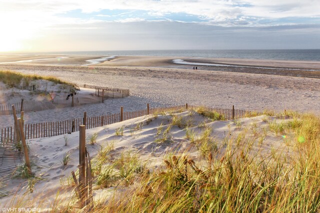 water view featuring fence and a view of the beach