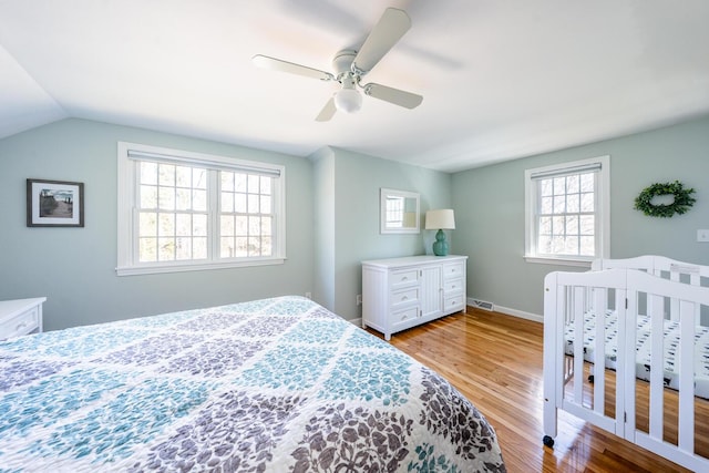 bedroom with visible vents, baseboards, lofted ceiling, ceiling fan, and light wood-type flooring