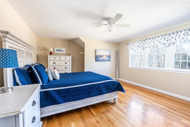 bedroom with baseboards, ceiling fan, and light wood-style floors