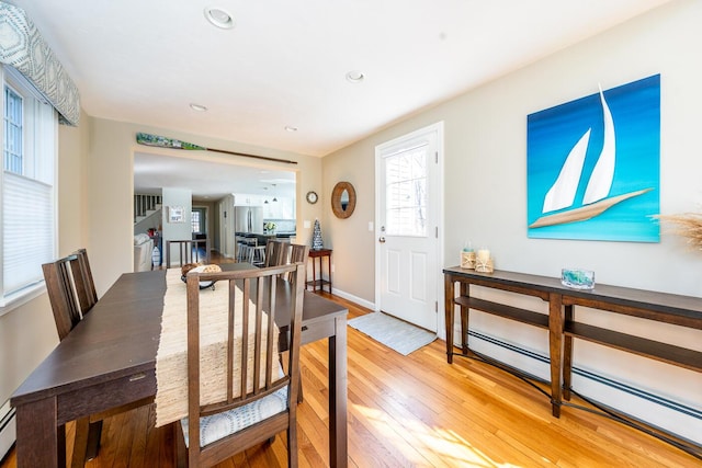 dining room featuring baseboards, recessed lighting, a baseboard radiator, and light wood-style floors