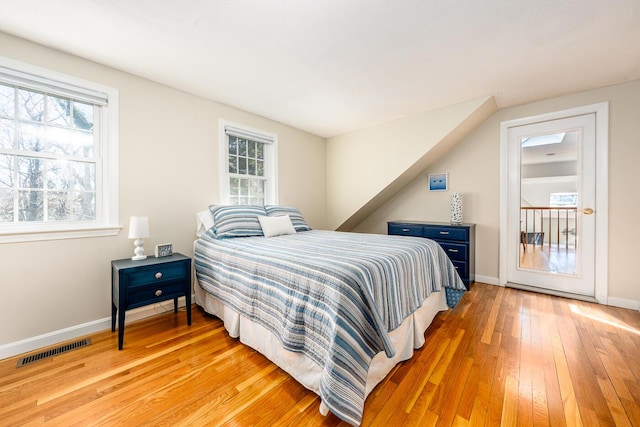 bedroom with light wood finished floors, baseboards, and visible vents