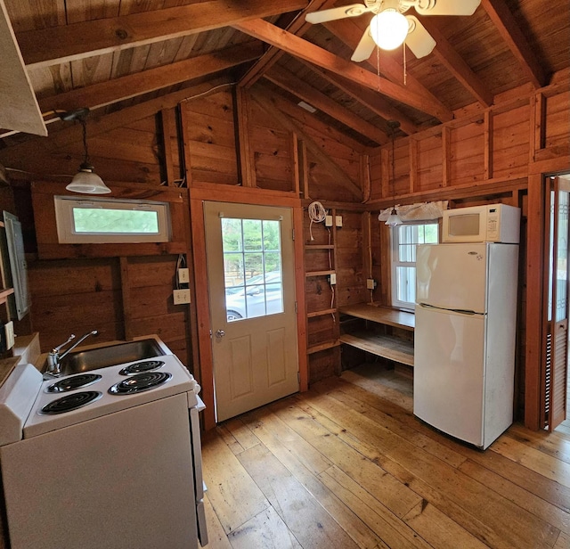 kitchen with wood walls, vaulted ceiling with beams, light wood-style flooring, and white appliances