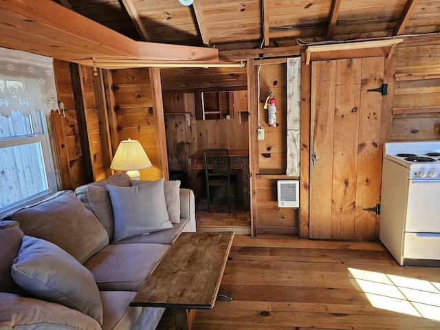 unfurnished living room featuring heating unit, wooden walls, and hardwood / wood-style flooring