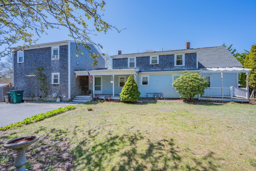 69 Upper County Rd, South Dennis, MA 02660 - back of property with covered porch, a chimney, and a yard