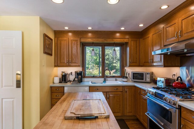 11 Polaris Dr, Mashpee, MA 02649 - kitchen with wood counters, a sink, appliances with stainless steel finishes, under cabinet range hood, and brown cabinets
