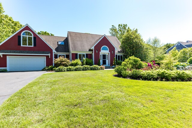 11 Polaris Dr, Mashpee, MA 02649 - view of front facade featuring a front lawn, driveway, an attached garage, and roof with shingles