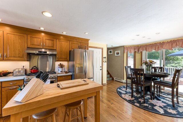 11 Polaris Dr, Mashpee, MA 02649 - kitchen featuring appliances with stainless steel finishes, under cabinet range hood, light wood finished floors, brown cabinets, and recessed lighting