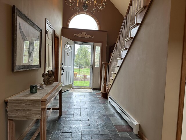 11 Polaris Dr, Mashpee, MA 02649 - entrance foyer featuring a baseboard radiator, stone tile floors, healthy amount of natural light, baseboards, and high vaulted ceiling