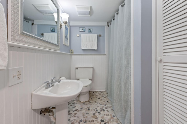 bathroom featuring toilet and wooden walls