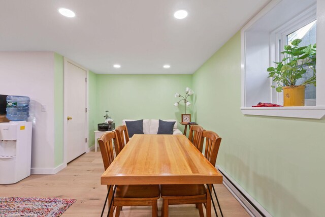 dining space featuring a baseboard radiator and light hardwood / wood-style floors