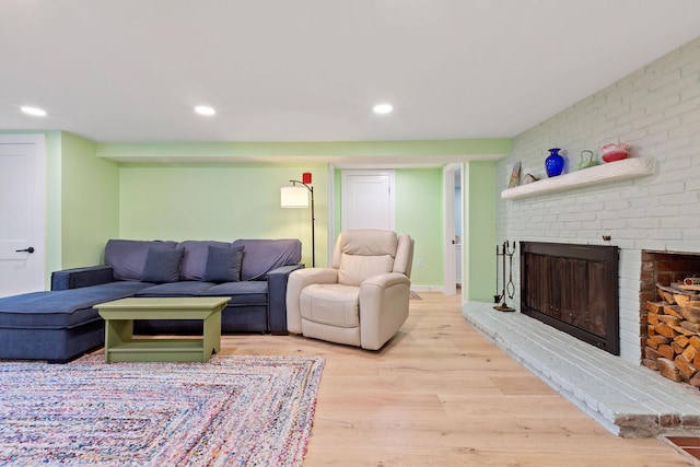 living room featuring a brick fireplace and light hardwood / wood-style flooring