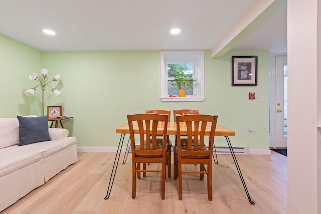 dining area with light hardwood / wood-style flooring and a baseboard heating unit