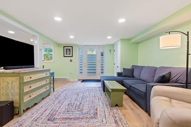 living room featuring baseboard heating and light hardwood / wood-style flooring