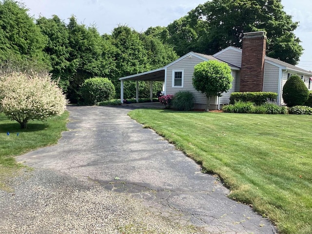 8 Saco Ave, Pocasset, MA 02559 - view of home's exterior featuring a lawn, driveway, a chimney, and a carport