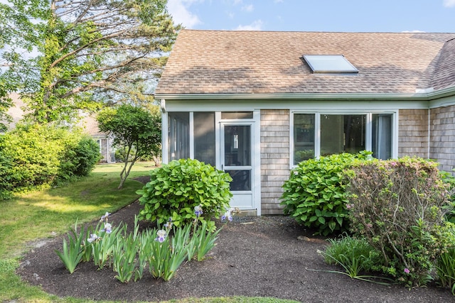 18 Juniper Cir, Brewster, MA 02631 - back of house with roof with shingles, a sunroom, and a yard