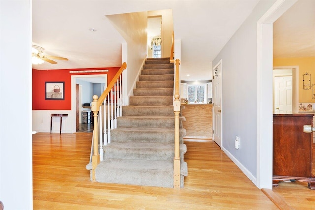 stairway featuring ceiling fan and hardwood / wood-style floors