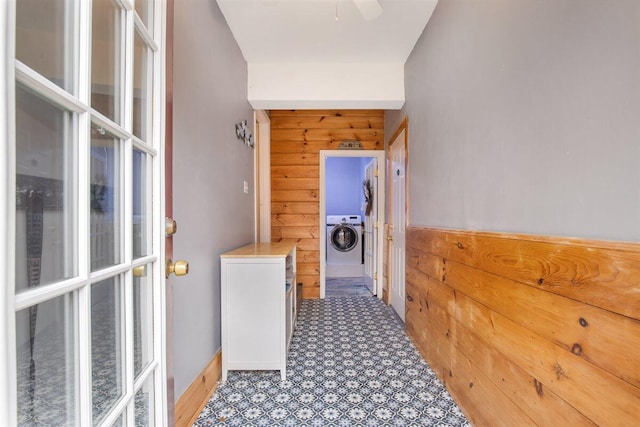 hallway featuring wooden walls and washer / clothes dryer