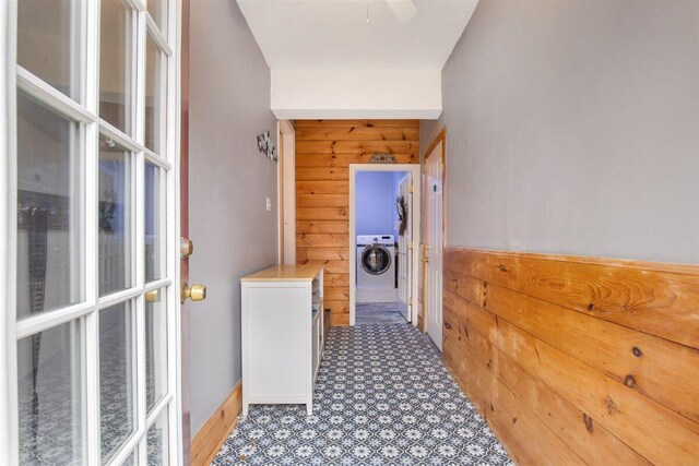 hallway featuring wooden walls and washer / clothes dryer