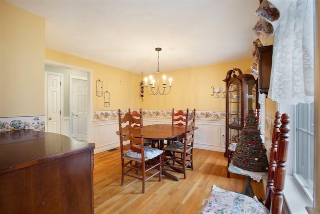 dining area featuring an inviting chandelier and light hardwood / wood-style flooring