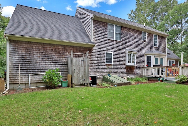 back of house featuring central AC unit, a lawn, and a wooden deck