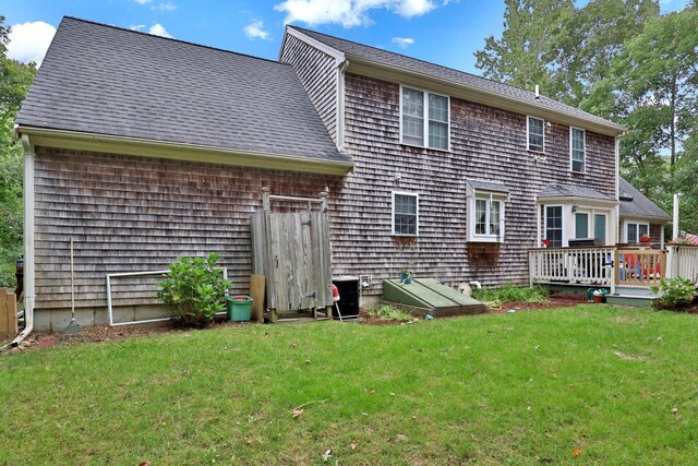 back of house featuring central AC unit, a lawn, and a wooden deck