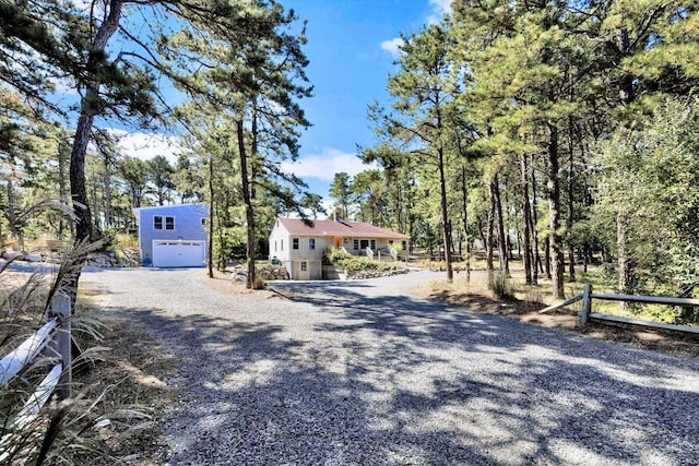 view of front of property with gravel driveway and fence