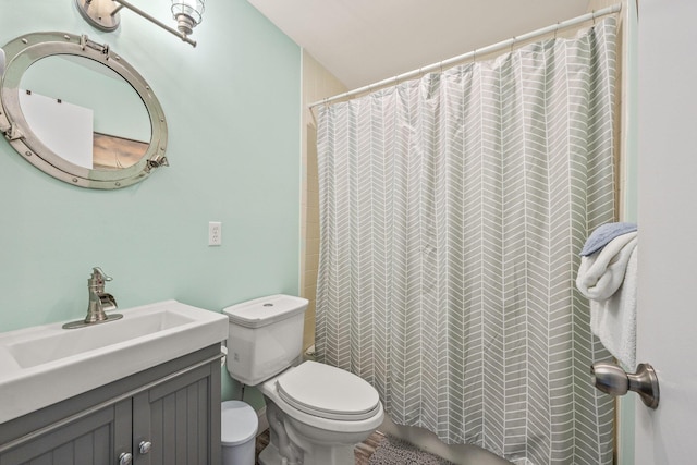 bathroom with curtained shower, toilet, and vanity