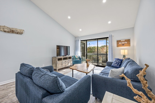 living room with light hardwood / wood-style floors and high vaulted ceiling