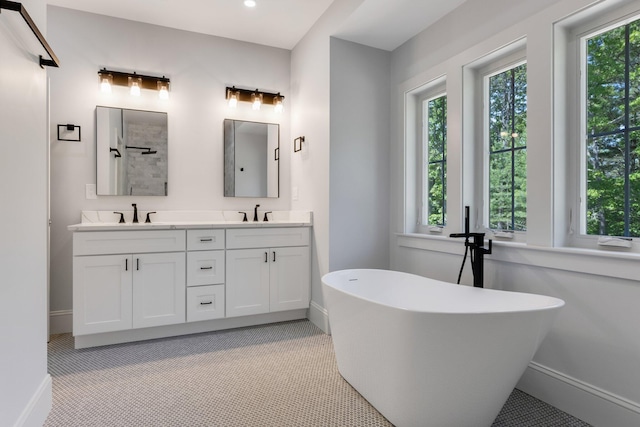 84 Hooppole Rd, Mashpee, MA 02649 - bathroom with double vanity, a freestanding tub, a tile shower, baseboards, and recessed lighting