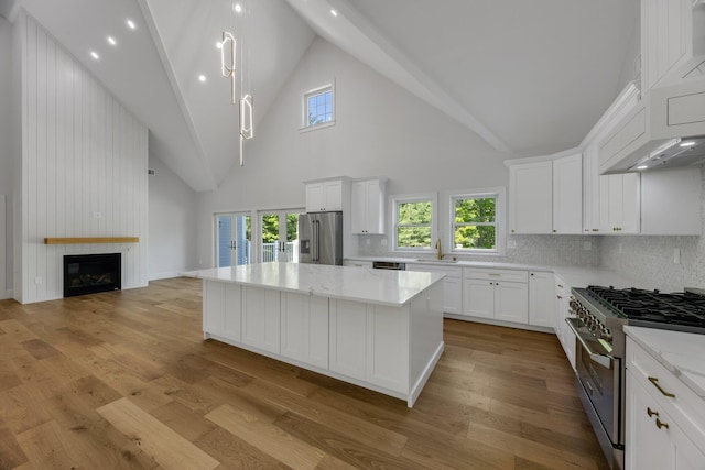 84 Hooppole Rd, Mashpee, MA 02649 - kitchen featuring premium appliances, a sink, a kitchen island, white cabinets, and high vaulted ceiling