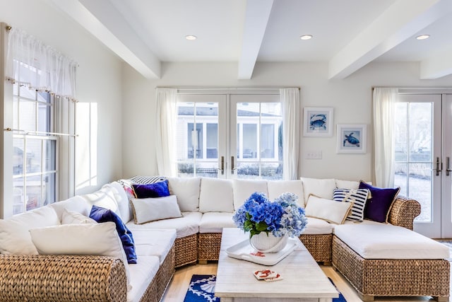 living room with a wealth of natural light, beam ceiling, and french doors