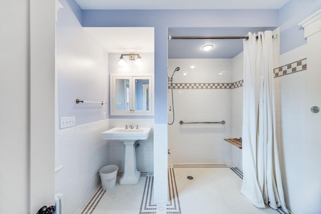 bathroom with tile walls, sink, tile patterned flooring, and a shower with shower curtain