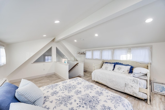 bedroom featuring multiple windows, light hardwood / wood-style flooring, and vaulted ceiling with beams