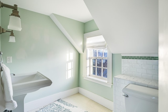 bathroom featuring lofted ceiling and toilet