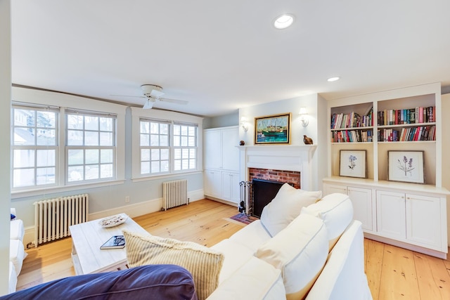 10 Bank St, Wellfleet, MA 02667 - living area featuring radiator heating unit, light wood-style flooring, ceiling fan, a brick fireplace, and recessed lighting