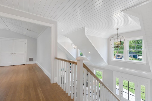 9 Joy Ln, Orleans, MA 02653 - hallway featuring a chandelier, vaulted ceiling, wood finished floors, wooden ceiling, and an upstairs landing