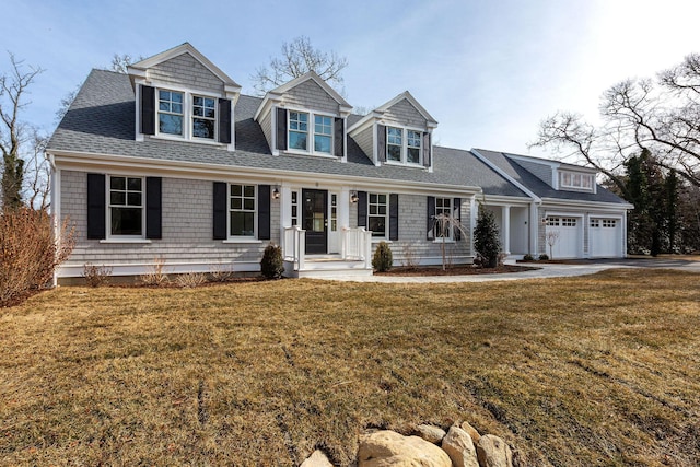 cape cod home with a garage and a front lawn