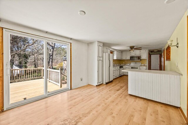 261 Old Chatham Rd, South Dennis, MA 02660 - kitchen with stainless steel microwave, freestanding refrigerator, a peninsula, a ceiling fan, and range with electric stovetop