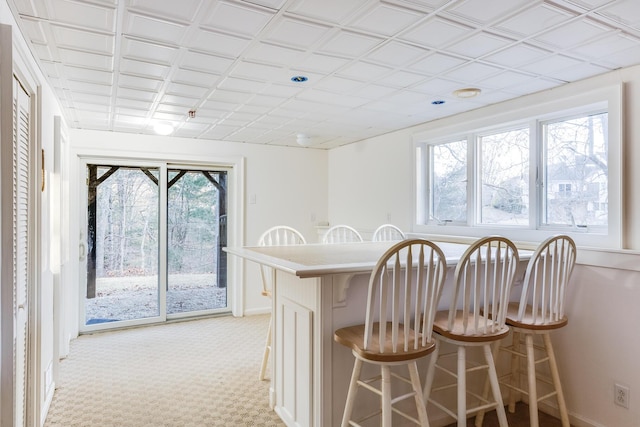 181 Leisure Green Dr, Mashpee, MA 02649 - kitchen with a kitchen bar, baseboards, a peninsula, and light countertops
