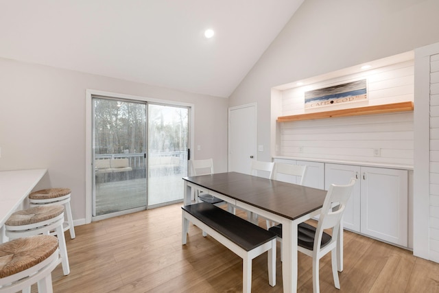 dining room featuring light wood-style floors and high vaulted ceiling